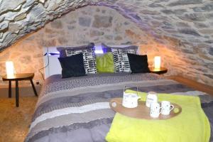 a bedroom with a bed with a stone wall at Cocoon,Vue Montagne,Jacuzzi privé in Mostuéjouls