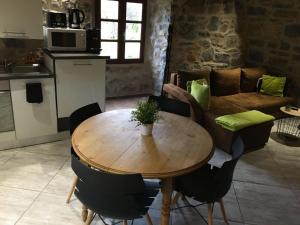 a wooden table and chairs in a living room at Cocoon,Vue Montagne,Jacuzzi privé in Mostuéjouls +13 photos