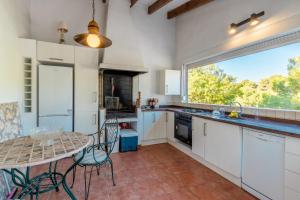 a kitchen with white cabinets and a table and a window at El Refugio - Quite and Spacious in Benissa