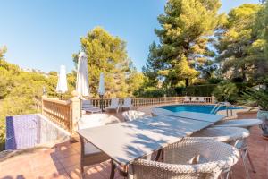 a patio with a table and chairs and a swimming pool at El Refugio - Quite and Spacious in Benissa