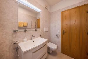 a bathroom with a sink and a toilet and a mirror at Stompferhof Erkerwohnung in Caldaro +5 photos