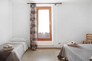 ein Schlafzimmer mit zwei Betten und einem Fenster in der Unterkunft Pin e cele in Dronero