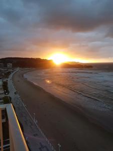 a view of a beach with the sun setting at Piso en el Mar in Salinas