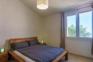 a bedroom with a bed and a window at Il Sughereto In Vigna in Aglientu