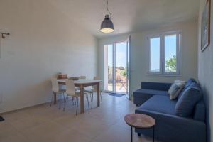 a living room with a blue couch and a table at Il Sughereto In Vigna in Aglientu