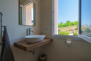 a bathroom with a bowl sink and a window at Il Sughereto In Vigna in Aglientu