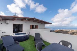 a patio with chairs and a view of the ocean at Vv El Mirador in El Palmital