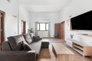 a living room with a couch and a flat screen tv at Vv El Mirador in El Palmital