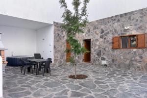 a room with a table and chairs and a tree at Vv El Mirador in El Palmital