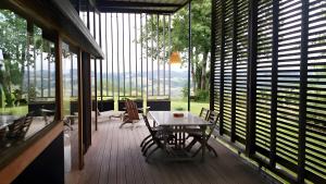 a room with a table and chairs on a deck at Gite Dilos in Gan +8 photos