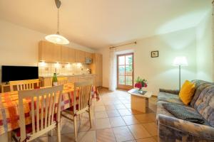 a living room and kitchen with a table and a couch at Stettnerhof Wohnung Laugen in Vollan