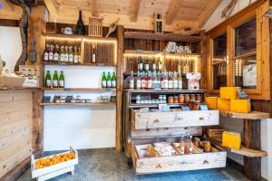 a store with wooden walls and shelves with bottles at Stettnerhof Wohnung Laugen in Vollan +8 photos