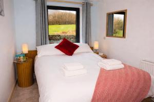 a bedroom with a white bed with red pillows and a window at The Foveran in Kirkwall +18 photos
