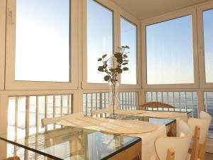 a dining room with a table and chairs and windows at Piso en el Mar in Salinas