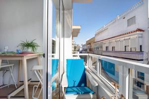 a balcony with a blue chair and a table at Apartamento Caepionis in Chipiona