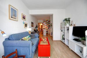 a living room with a blue couch and a red table at Apartamento Caepionis in Chipiona