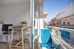 an apartment with a balcony with a table and a train at Apartamento Caepionis in Chipiona