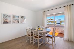 a dining room with a table and chairs and a window at Justo's House in Faro