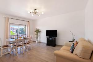a living room with a couch and a dining room table at Justo's House in Faro