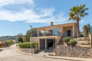 a house on a street with a palm tree at Villa Elodia in Calonge