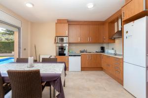 a kitchen and dining room with a table and a refrigerator at Villa Elodia in Calonge