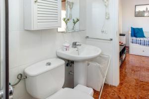 a white bathroom with a toilet and a sink at Casa La Palmilla in San Nicolás +11 photos