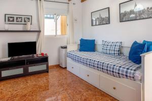a bedroom with a bed with blue pillows and a tv at Casa La Palmilla in San Nicolás