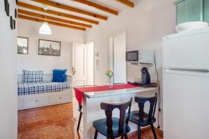 a kitchen with two bar stools and a refrigerator at Casa La Palmilla in San Nicolás