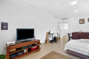 a living room with a television on a wooden entertainment center at Ca Blanca Paraíso ll in Denia
