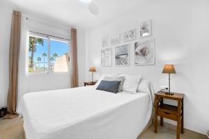 a white bedroom with a white bed and a window at Ca Blanca Paraíso ll in Denia +15 photos