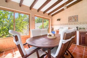 a dining room with a wooden table and chairs at Ca Blanca Paraíso ll in Denia