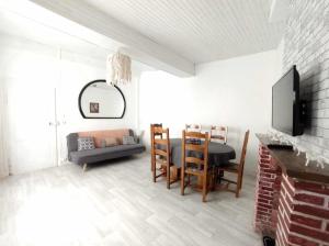 a living room with a table and chairs and a tv at Séjour familial au Gite Iza – Lorme in Lormes