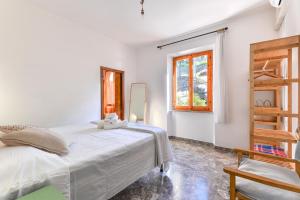 a white bedroom with a bed and a window at Casa Magnolia P1 in Seccheto