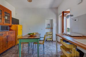a kitchen with a table with a bowl of fruit on it at Casa Magnolia P1 in Seccheto +17 photos