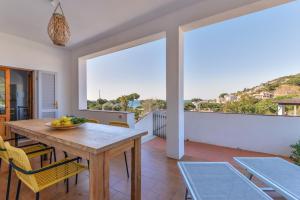 a dining room with a table and chairs and a balcony at Casa Magnolia P1 in Seccheto