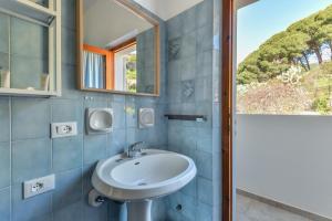 a bathroom with a sink and a mirror at Casa Magnolia P1 in Seccheto