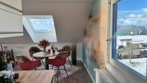a room with a table and chairs and a window at Studio Dinkelberg in Adelhausen