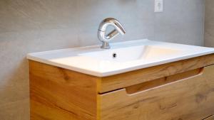 a sink in a bathroom with a wooden vanity at Studio Dinkelberg in Adelhausen +23 photos