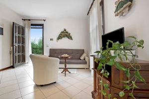 a living room with a couch and a chair at Stella del Garda 1 con balcone in Tignale