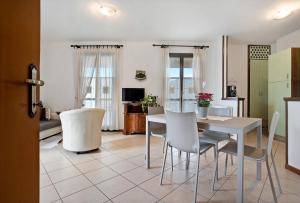 a kitchen and dining room with a table and chairs at Stella del Garda 1 con balcone in Tignale