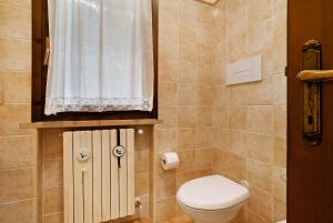 a small bathroom with a toilet and a window at Stella del Garda 1 con balcone in Tignale +24 photos