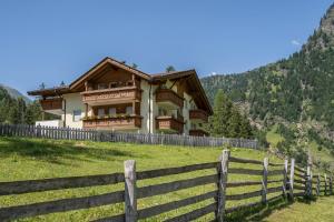 a house in a field next to a fence at Ferienhaus Maria Edelweiss in Moso