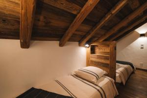 two beds in a room with wooden ceilings at Gîte Maria in La Tour