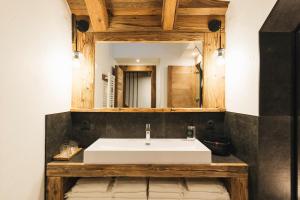 a bathroom with a white sink and a mirror at Gîte Maria in La Tour +9 photos