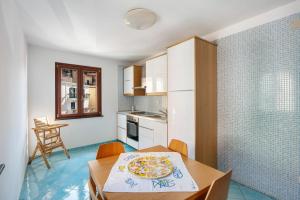 a kitchen with a table with a pizza on it at Ce Tour - Casa Cetara Centro in Cetara