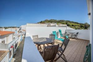 a balcony with chairs and a table on a roof at Casa Da Paz in Salema