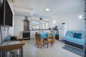 a kitchen and living room with a table and a couch at Casa Da Paz in Salema