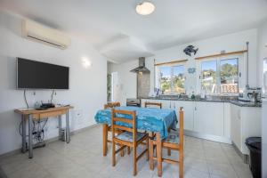 a kitchen with a table and a tv in a room at Casa Da Paz in Salema