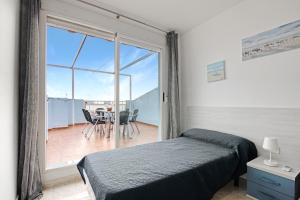 a bedroom with a bed and a balcony with a table and chairs at Casa Pera in Xilxes