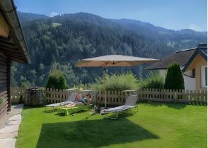 a person laying on a lawn with an umbrella at Chalet Berger in Sankt Johann im Pongau